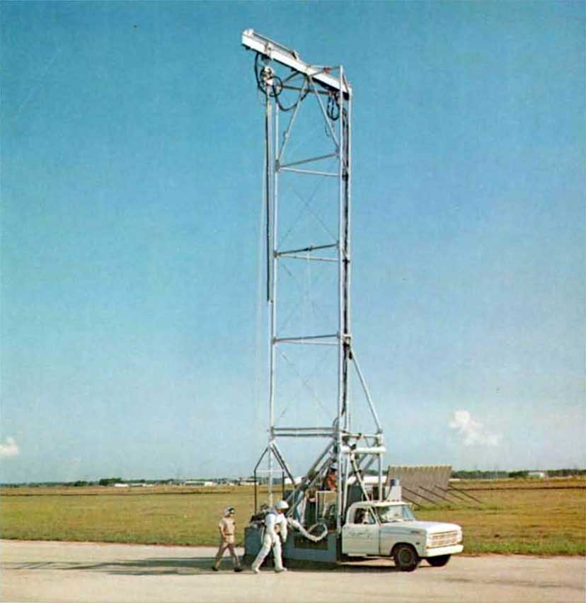 A photo of a pulley-mounted truck lifting an astronaut slightly off the ground