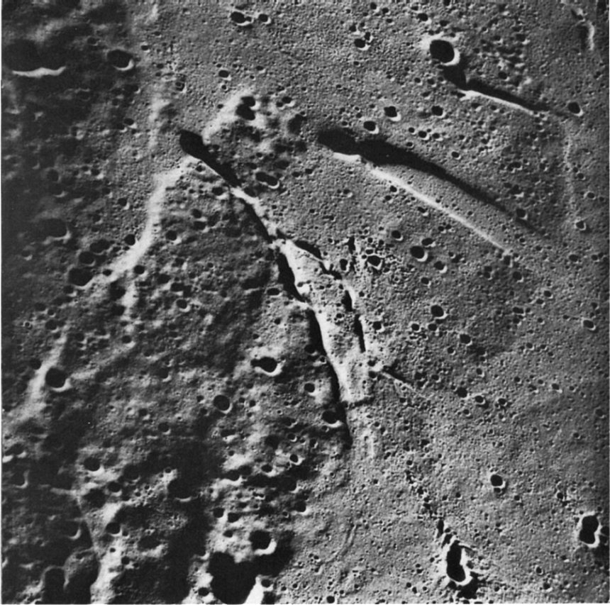 FIGURE 219. - A low Sun angle view of the western part of the Aristarchus Plateau shows three sharp rimmed linear depressions that occur in the higher unit and terminate at the edge of the plateau.